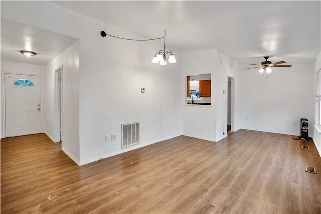 unfurnished living room featuring ceiling fan with notable chandelier and light wood-type flooring