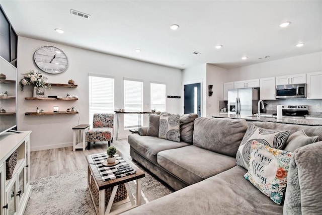 living room featuring sink and light wood-type flooring