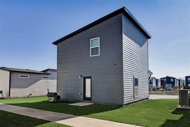 rear view of property with a yard and cooling unit