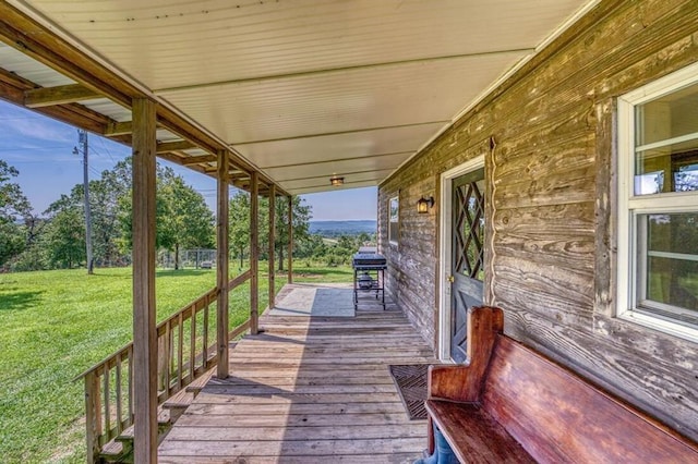 wooden deck featuring a lawn