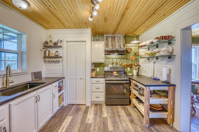 kitchen featuring sink, light hardwood / wood-style flooring, stainless steel range with gas stovetop, white cabinets, and wooden ceiling