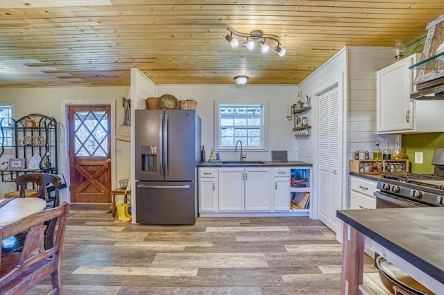 kitchen featuring white cabinetry, sink, range, and stainless steel fridge