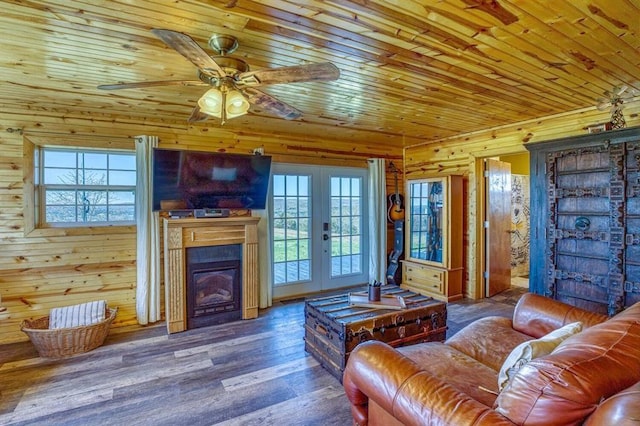 living room with wood walls, hardwood / wood-style flooring, ceiling fan, wooden ceiling, and french doors