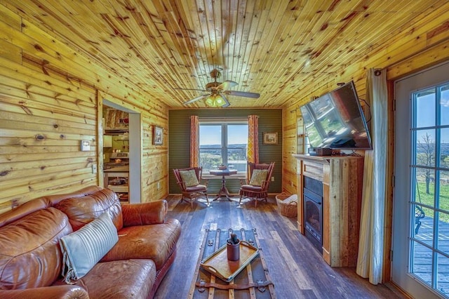 living area featuring wood ceiling, dark hardwood / wood-style floors, ceiling fan, and wood walls