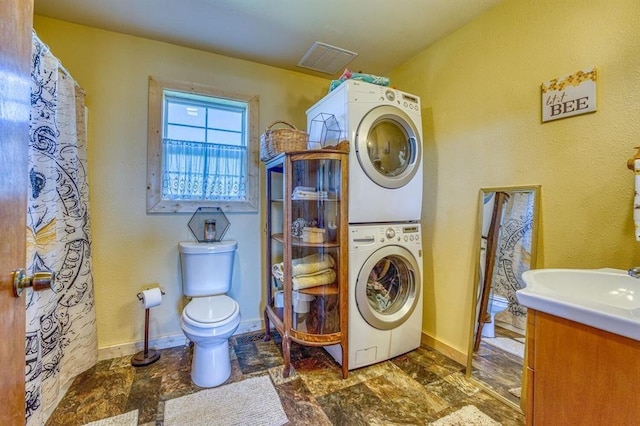 laundry area with stacked washer and clothes dryer and sink