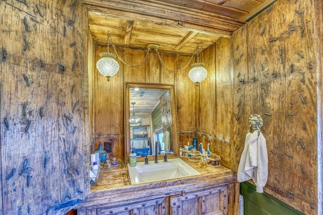 bathroom with wood ceiling, vanity, and wood walls