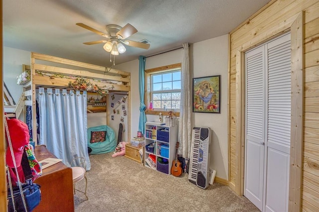 carpeted bedroom featuring a textured ceiling, ceiling fan, and a closet