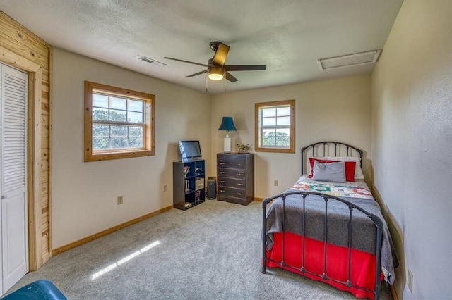 carpeted bedroom featuring ceiling fan and a textured ceiling