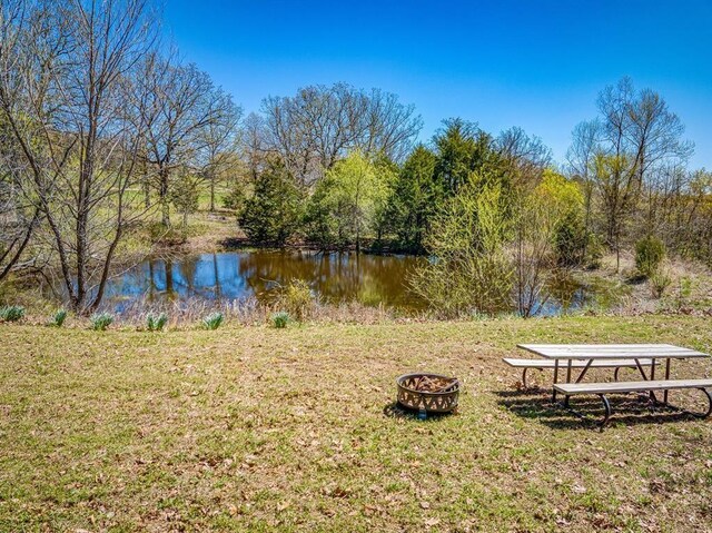 exterior space with a water view and a fire pit