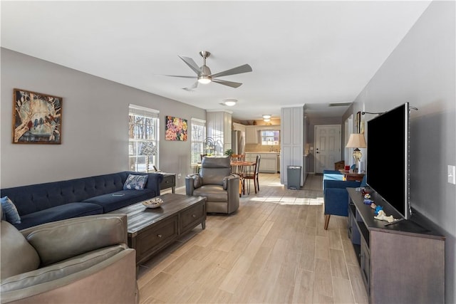 living room with ceiling fan and light hardwood / wood-style floors