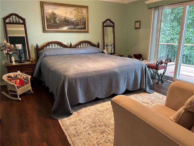 bedroom with ornamental molding, wood finished floors, and access to exterior