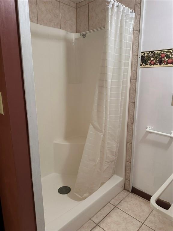 bathroom with tile patterned flooring and a shower stall