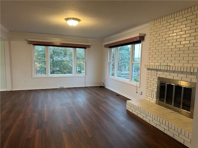 unfurnished living room with a textured ceiling, visible vents, ornamental molding, a brick fireplace, and dark wood-style floors