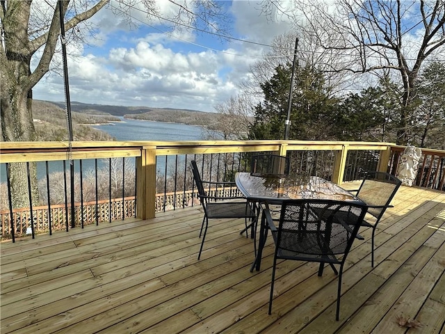 wooden terrace with a water view and outdoor dining area