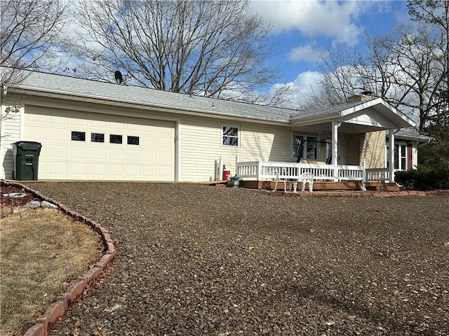 ranch-style home with a garage, driveway, a porch, and roof with shingles