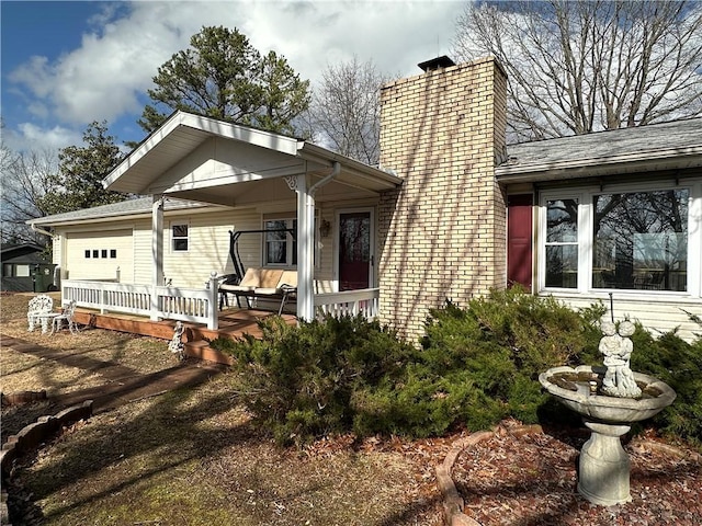 view of front facade with a garage and a chimney