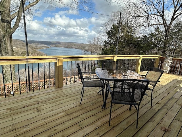 deck featuring outdoor dining space and a water view