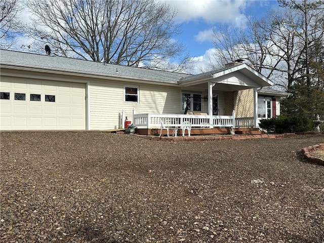 ranch-style home with a garage, dirt driveway, and a porch