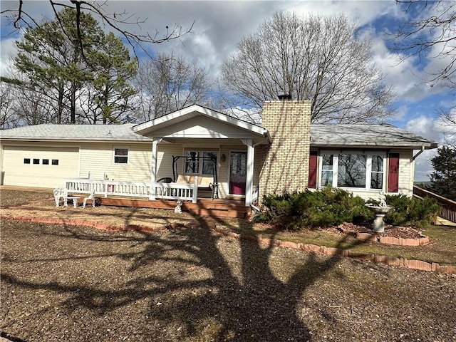 ranch-style house with covered porch, a chimney, and an attached garage