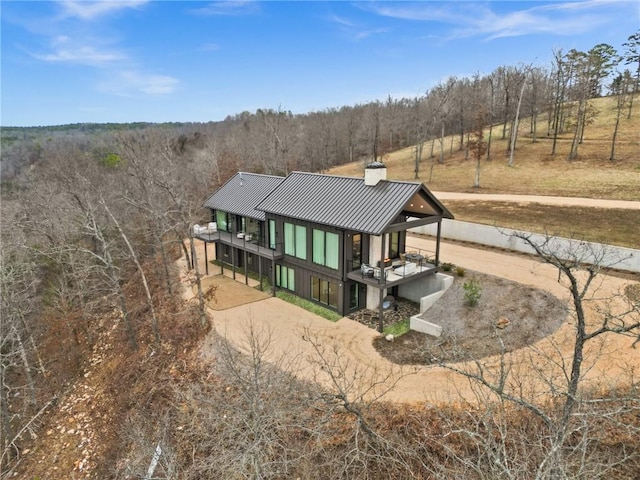 back of property featuring a rural view and a balcony