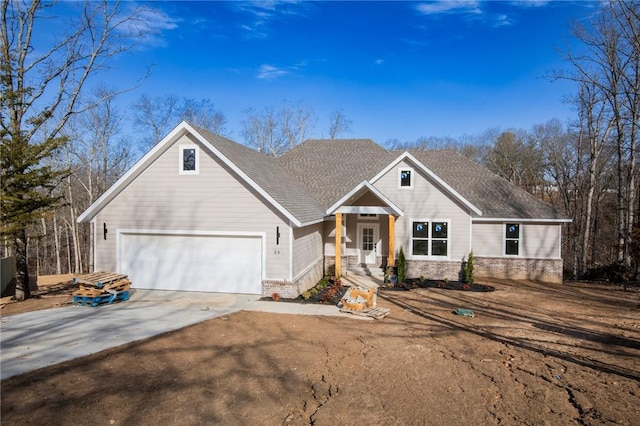 view of front of house with a shingled roof, concrete driveway, and brick siding