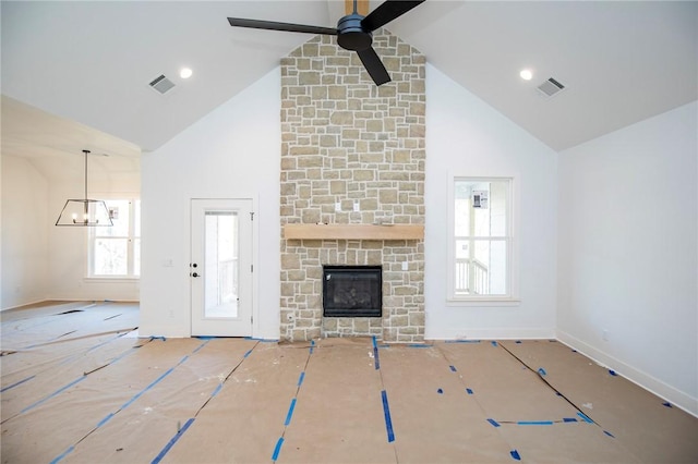 unfurnished living room featuring high vaulted ceiling, visible vents, a stone fireplace, and a ceiling fan