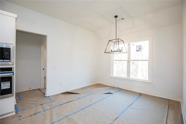 unfurnished dining area featuring visible vents, a notable chandelier, and baseboards