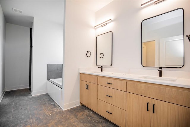 full bath featuring double vanity, baseboards, visible vents, a garden tub, and a sink