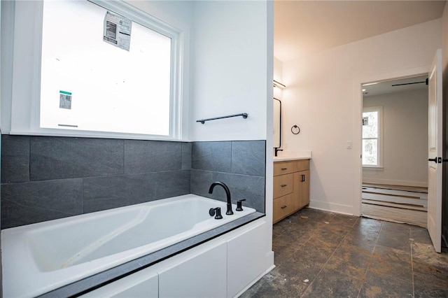 bathroom with a garden tub and vanity