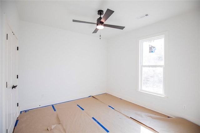 spare room featuring ceiling fan and visible vents