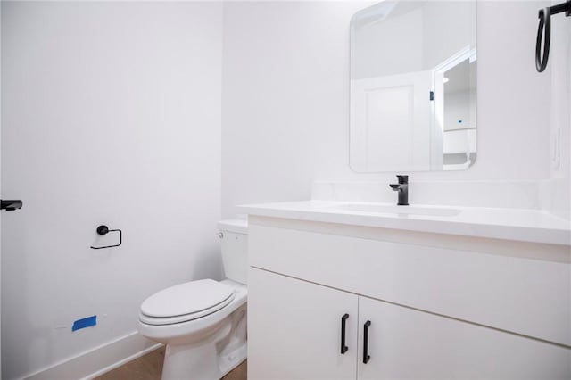 20 Singleton Dr, Bella Vista, AR 72715 - half bathroom featuring vanity, toilet, wood finished floors, and baseboards