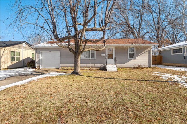 back of property with a garage and a lawn