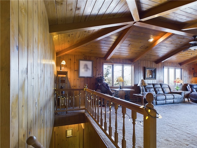 carpeted living room featuring a healthy amount of sunlight and wood walls