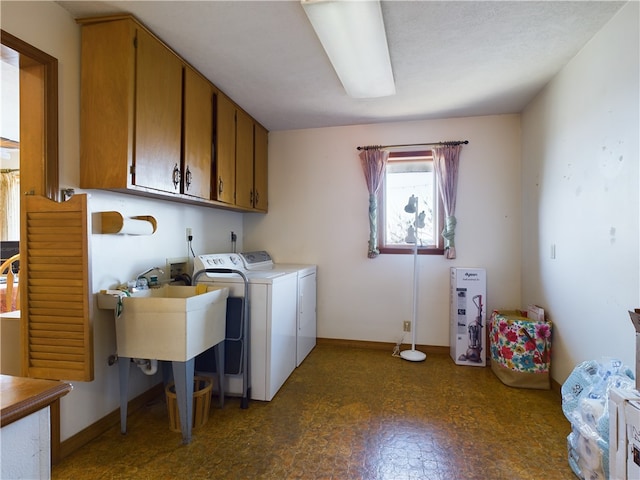 washroom with washer and dryer and cabinets