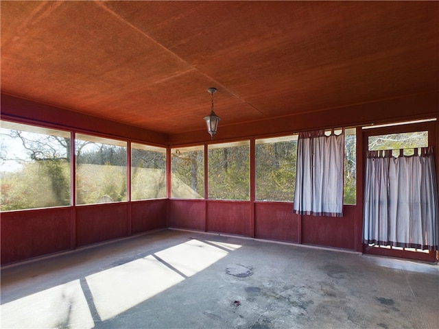 unfurnished sunroom featuring wood ceiling and a healthy amount of sunlight