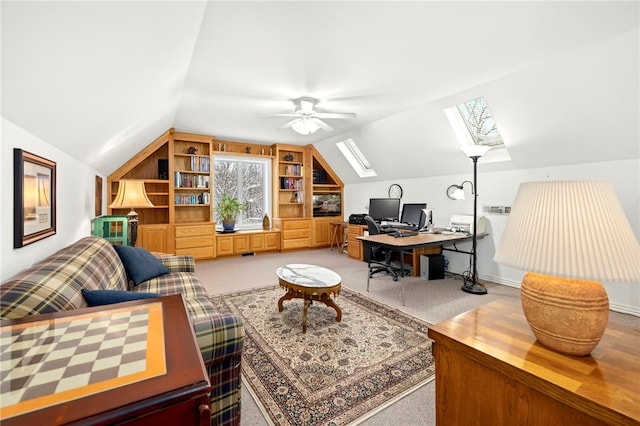 carpeted home office with lofted ceiling with skylight and ceiling fan