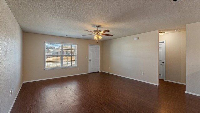 empty room featuring a textured ceiling, dark wood-type flooring, and ceiling fan