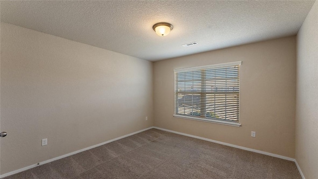 carpeted empty room with a textured ceiling