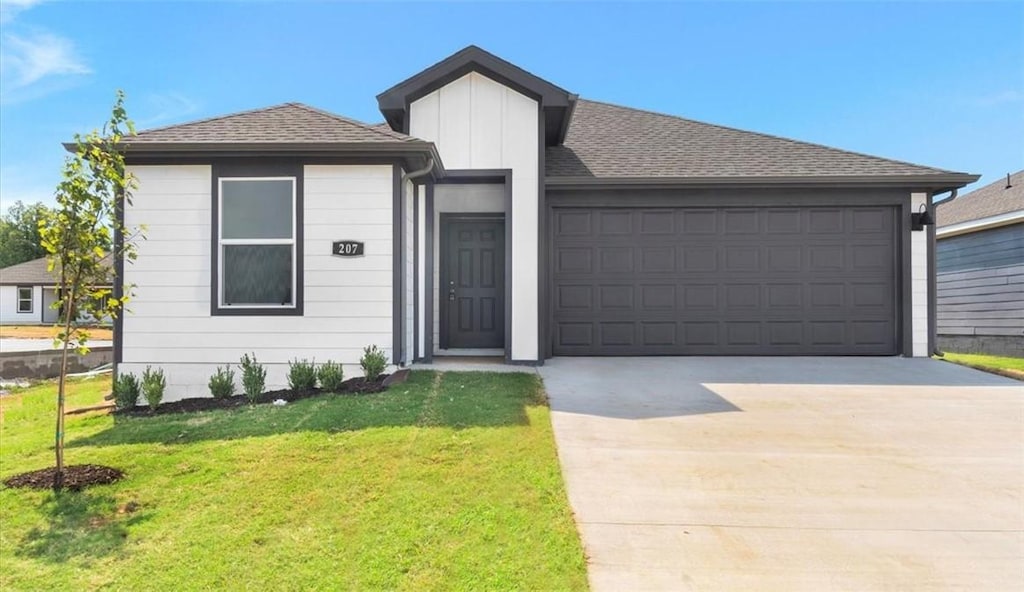 view of front of property with a front yard and a garage