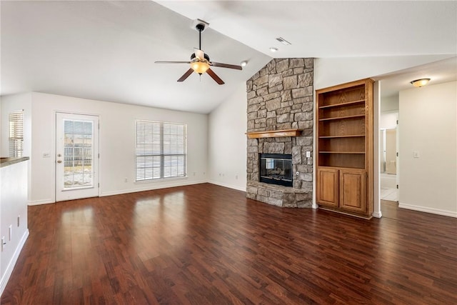 unfurnished living room with ceiling fan, dark hardwood / wood-style flooring, a stone fireplace, and lofted ceiling