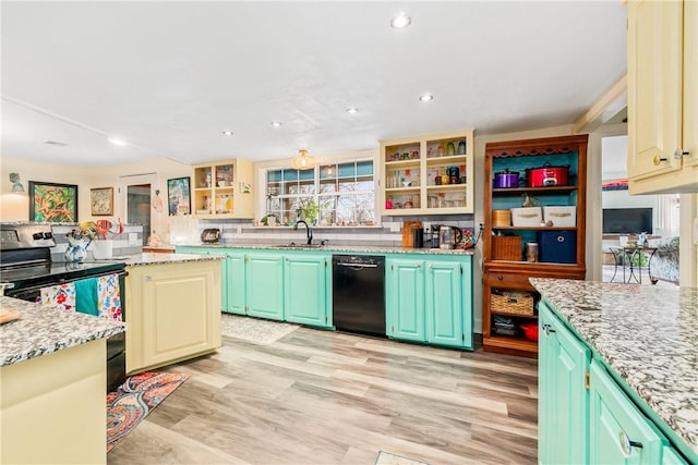 kitchen featuring light stone countertops, light wood-type flooring, sink, black appliances, and green cabinetry