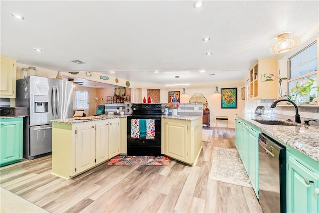 kitchen featuring stainless steel fridge, light stone counters, black range with electric cooktop, dishwasher, and a kitchen island