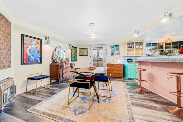 dining space with wood-type flooring and heating unit