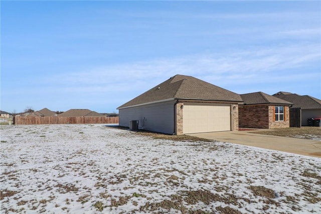 view of snow covered exterior with a garage