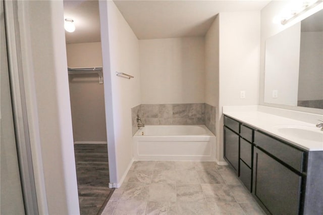 bathroom featuring vanity and a washtub