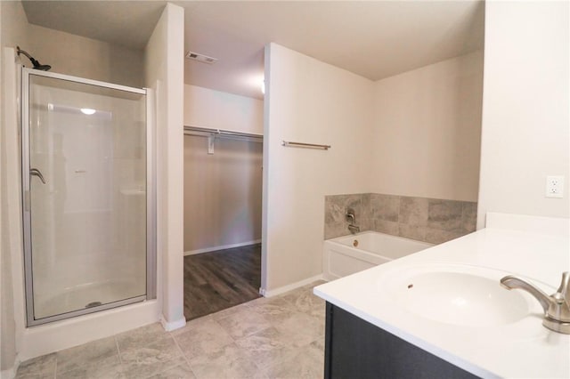 bathroom with vanity and independent shower and bath