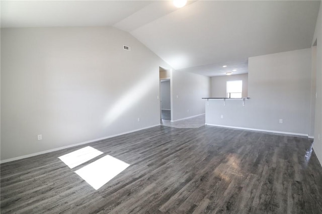 empty room featuring vaulted ceiling and dark wood-type flooring