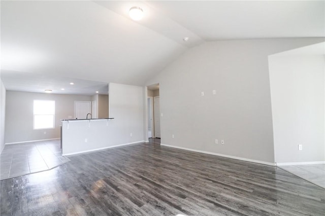 unfurnished living room featuring dark hardwood / wood-style flooring and vaulted ceiling