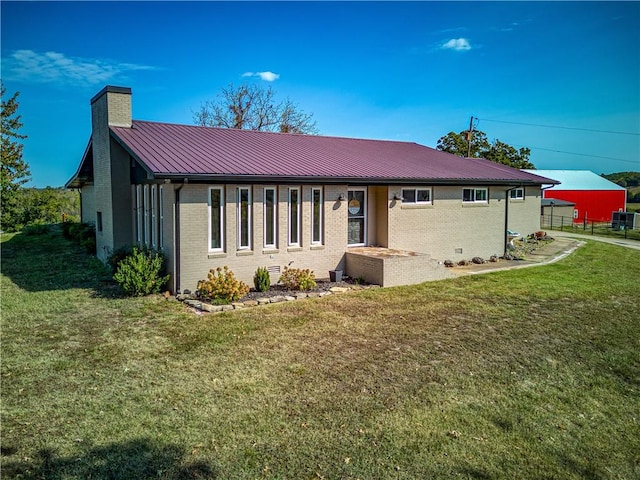 view of front of home with crawl space, brick siding, a chimney, and a front lawn