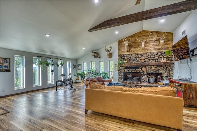 living area featuring a fireplace, visible vents, wood finished floors, beamed ceiling, and baseboards